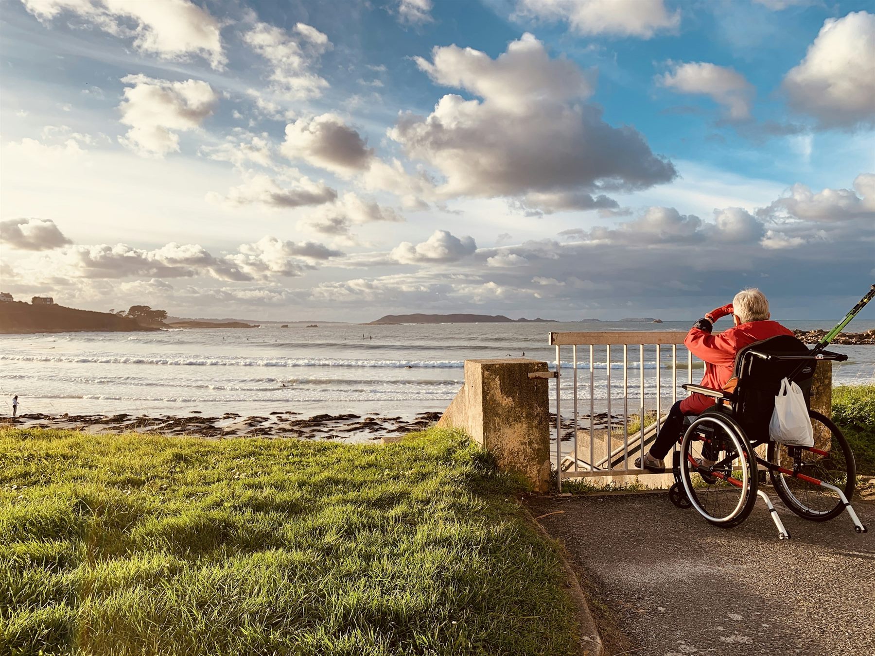 A person in a wheelchair looking out at the sea